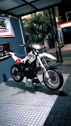 a white and black motorcycle parked in front of a building