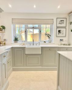 a large kitchen with white cabinets and marble counter tops, along with an open window to let in natural light