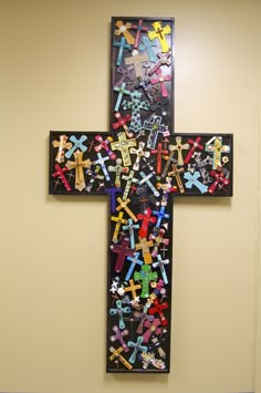 a cross made out of crosses is hanging on the wall