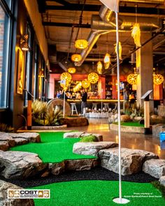 an indoor golf course with flags and rocks