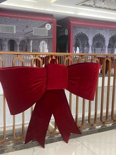 a red bow sitting on top of a metal rail