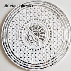 an intricately designed white plate on a table