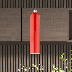 a red light hanging from the side of a wooden wall next to plants and flowers