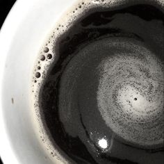 the inside of a coffee cup with black and white liquid in it, viewed from above