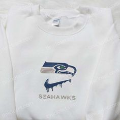 Seattle Seahawks x Nike Drip Embroidered Shirt, NFL Sports Embroidered Hoodie, Best Fandom Gift Ideas Nestled in the heart of Seattle, Tinicloset stands as a beacon of personalized fashion and unwavering team spirit, offering a curated collection of custom embroidered shirts, sweatshirts, T-shirts, and hoodies that epitomize the intersection of style and sports fandom. As purveyors of quality craftsmanship and individual expression, Tinicloset invites customers to explore a world where every sti White Collegiate Sweatshirt With Custom Embroidery, White Team Spirit Sweatshirt With Embroidered Graphics, White Sweatshirt With Embroidered Graphics For Team Spirit, Custom Embroidered Fleece Tops For Streetwear, Cotton Sports Hoodie With Embroidered Graphics, Varsity Sweatshirt With Custom Embroidery For Streetwear, Sporty College Hoodie With Custom Embroidery, White Crew Hoodie With Embroidered Graphics, White Sweatshirt With Embroidered Sports Graphics