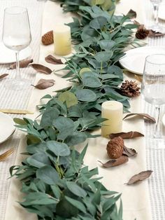 the table is set with candles and greenery