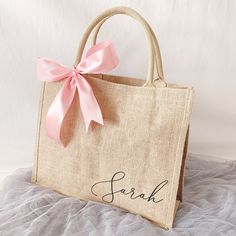 a handbag with a pink bow on the handle that says,'fark '