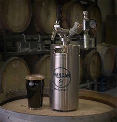 a beer keg next to a glass on a barrel