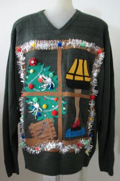 a green sweater with a christmas tree on the front and a lamp hanging from it's side