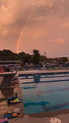 a rainbow in the sky over a swimming pool