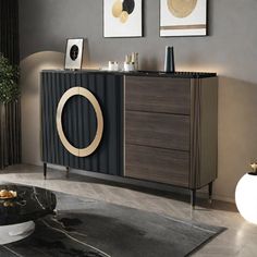 a black and brown cabinet in a living room with two pictures on the wall above it