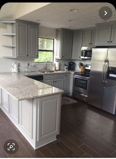 a large kitchen with stainless steel appliances and granite counter tops, along with hardwood flooring