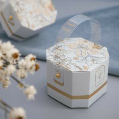 an open box sitting on top of a table next to white flowers and blue cloth