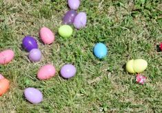 an assortment of colored eggs laying on the grass