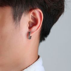 a close up of a person's ear wearing a pair of earrings with an animal design on it