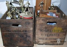 two wooden boxes with trophies in them sitting on a table next to another box filled with other items