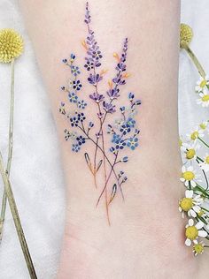 a flower tattoo on the ankle with daisies and daisies in the foreground