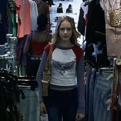 a woman standing in front of clothing racks