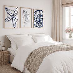 a bedroom with two pictures on the wall above the bed and an ocean themed rug