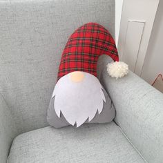 a grey couch with a red and black plaid santa hat on it's head