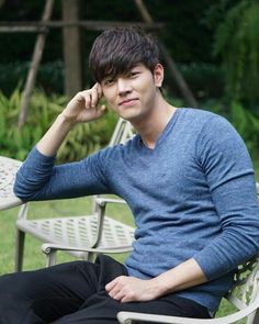 a young man sitting on top of a white chair