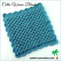 a blue crocheted dishcloth on top of a white table with palm trees in the background