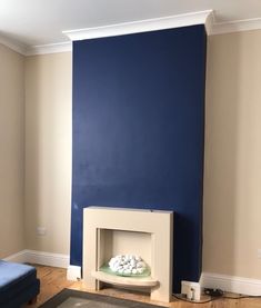 a living room with blue walls and white furniture in the corner, including a fireplace