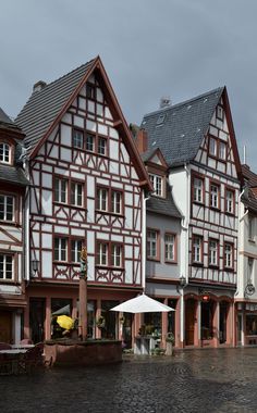 several buildings line the street with umbrellas in front of them on a rainy day