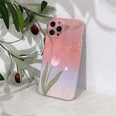 a pink phone case sitting on top of a white table next to a tree branch