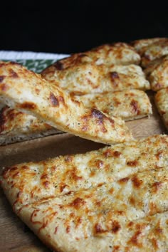 slices of cheese pizza sitting on top of a cutting board