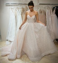 a woman standing in front of some dresses