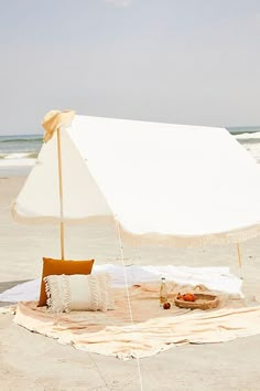 an umbrella is set up on the beach to shade people from the sun and relax