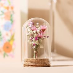 a glass dome with flowers in it sitting on a table