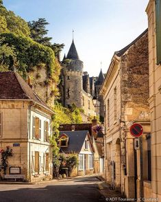 a narrow street with buildings and a castle in the background