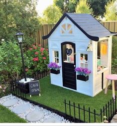 a small white and black doll house on grass