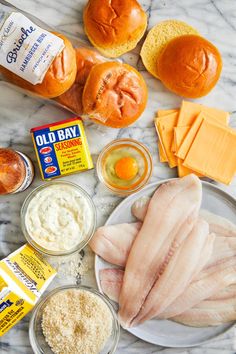 an assortment of ingredients on a marble countertop including bread, eggs, butter and cheese