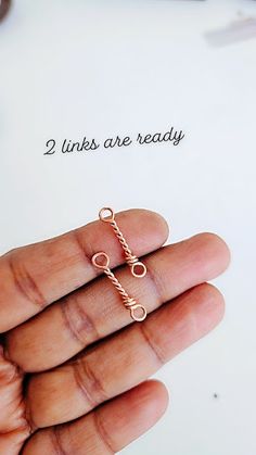 a hand holding a tiny cross ring with the words 2 lines are ready on it