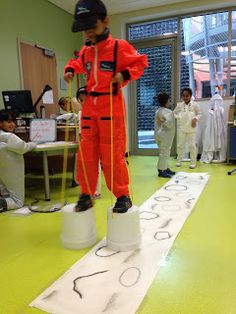 a man in an orange jumpsuit standing on top of a bucket and measuring tape