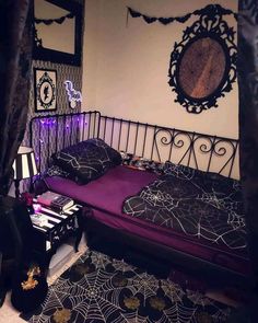 a bed with purple sheets and spider webs on it