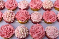 cupcakes with pink frosting and flowers on them are displayed in a box