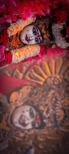 a doll is laying on the floor next to some flowers and petals in front of it