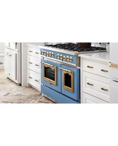 a blue and white stove top oven in a kitchen next to some cabinets with gold pulls