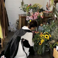 a woman arranging flowers in a flower shop