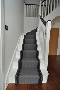 the stairs are lined with black and white carpet