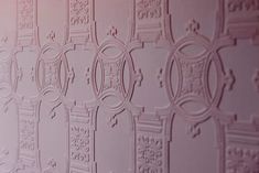 a close up view of some decorative designs on a wall in a room with pink walls