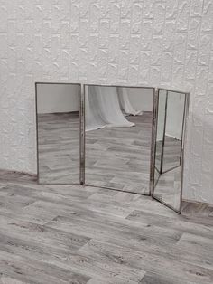 three mirrors sitting on top of a wooden floor