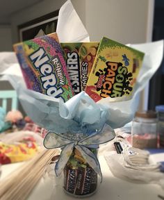 a vase filled with candy and wrapped in blue ribbon sitting on top of a table