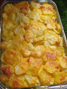 a casserole dish with potatoes in it on a green tableclothed surface