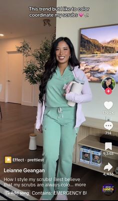 a woman in scrubs is holding a cup and standing next to a flat screen tv