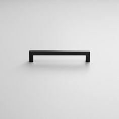 a black cabinet handle on a white wall